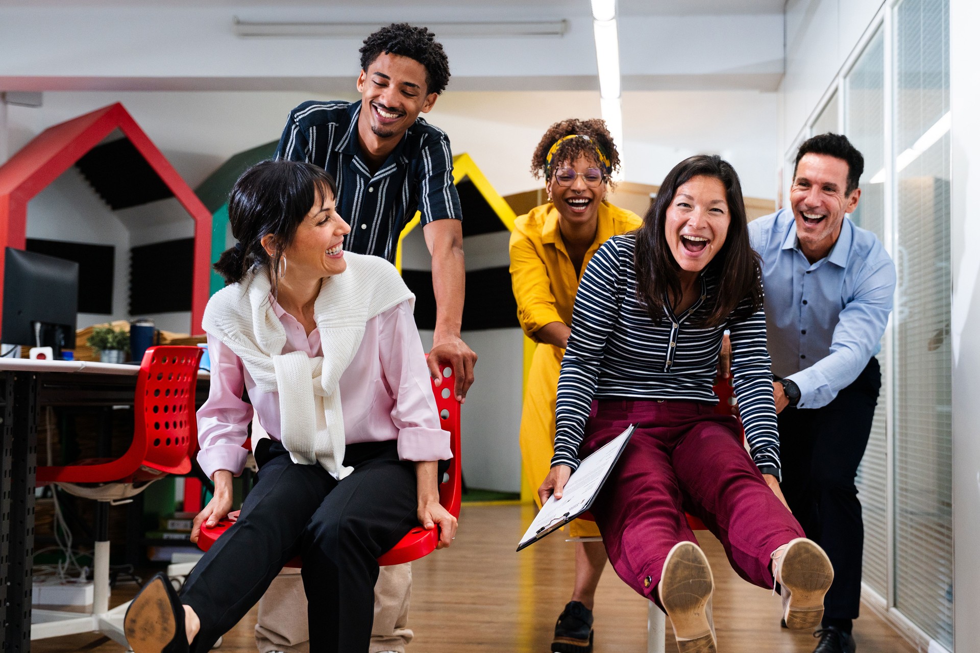 Happy business team having fun on office chairs in startup office